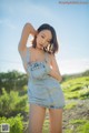 A woman in a denim dress posing for a picture.