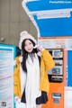 A woman standing in front of a vending machine.