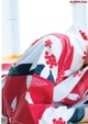 A woman in a red and white kimono laying on a bed.