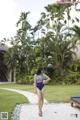 A woman in a blue and red bathing suit walking down a path.