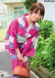 A woman in a pink kimono holding a basket.